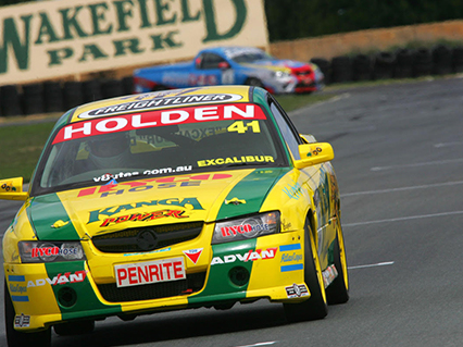 Up-close shot of driver Yanis Derums as he takes a corner in his number 41 Penrite yellow and green Kanga V8 Ute.